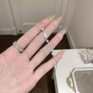 Detalle de pulsera de plata con colgante de calabaza pavimentada de circonitas finas.