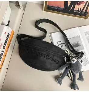 Trendy black streetwear crossbody chest bag with unique doll pendant for daily casual use.