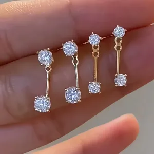 Detalle en primer plano de pendientes colgantes de doble cara en plata de ley y circonita.