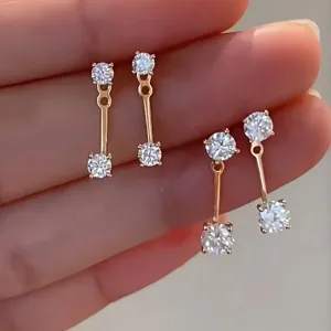 Primer plano detallado de pendientes colgantes de plata brillante, diseño fino y elegante.