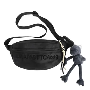 Detailed view of the black tactical chest bag with unique plush frog pendant and strap.