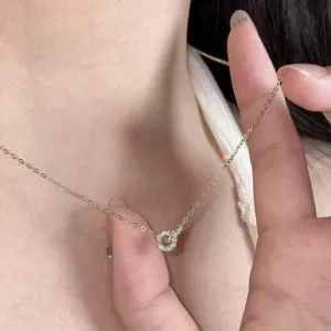 Gros plan détail du collier pendentif double anneau entrelacé étincelant de pierres.