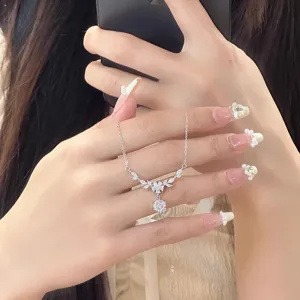 Close-up of delicate sterling silver zircon floral wheat necklace, elegant jewelry detail.