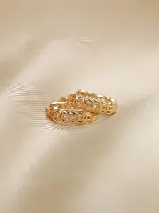 Primer plano detallado de un par de pendientes de aro dorados con diseño de moneda hueca.