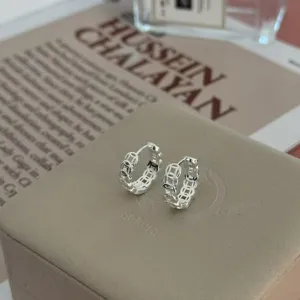 Vista de cerca de pendientes de aro de plata S999 con moneda hueca, joyería de lujo.