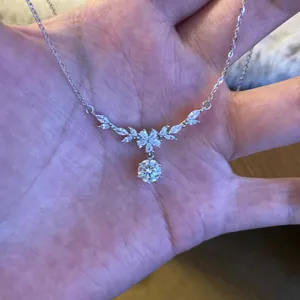 Close-up detail shot of the sparkling zircon floral necklace displayed neatly on a palm.