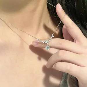 Close-up detail shot of a delicate silver flower and leaf clavicle chain necklace with sparkling zircon.