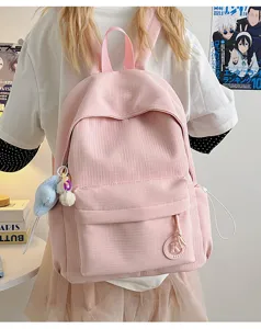 Pink student backpack with front pocket and cute pendant for daily commute and school use.