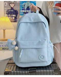 Detailed view of the light blue student backpack, showing textured fabric and front pocket.