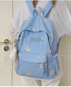 Hellblauer gesteppter Rucksack mit bunter Schmetterlingsstickerei und Vordertasche.