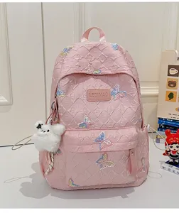 Rosa gesteppter Schulrucksack mit Pailletten-Schmetterlingen und süßem Plüschbäranhänger.