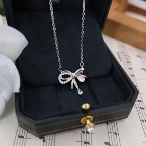 Vista detallada del collar de lazo de plata s925, con circonitas brillantes y una piedra rosa fina.