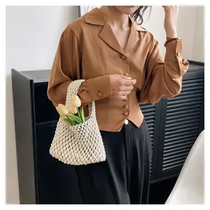 Détail de sac à main creux tissé à la main, sac panier en filet style vacances minimaliste.