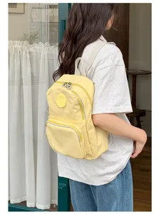 Sac à dos décontracté en nylon jaune avec poche avant et poignée, cartable élégant pour femmes.