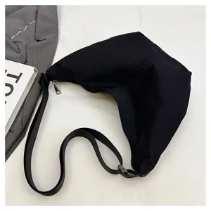 Bolso cruzado de nailon negro, toma detallada que muestra la cremallera y la correa.