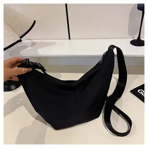 Detalle del bolso cruzado de nailon negro, que muestra tela duradera y correa ancha.