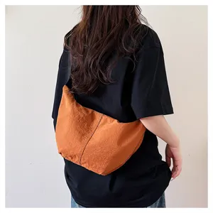 Bolso cruzado de nailon tipo cruasán informal, bolso dumpling color caramelo detalle.