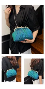 Détail en gros plan du sac de soirée plissé et dégradé avec un fermoir à strass étincelant.