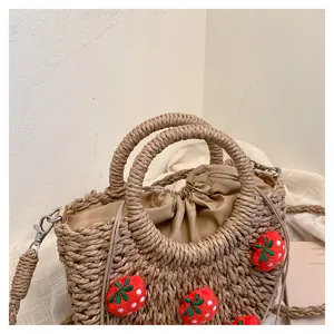 Strohgewebe Handtasche Detailansicht mit niedlichen Erdbeerdekorationen und Stofffutter innen.
