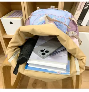 Backpack interior detail showing large capacity storage with books, umbrella and phone.
