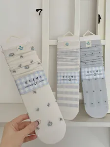 Detail view of light women's mid-tube socks, featuring floral, stripe and polka dot patterns.