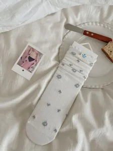 White mid-tube slouchy socks with blue floral lace trim, aesthetic style detail view.