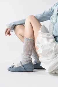 Grijze mesh voetloze sokken gecombineerd met blauwe platte ballet schoenen, detailweergave.