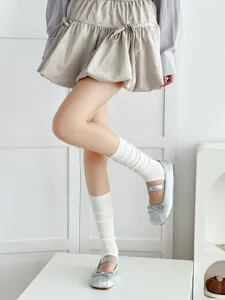 Spring summer trendy grey stirrup leg warmers paired with ballet style silver flats and skirt detail shot.