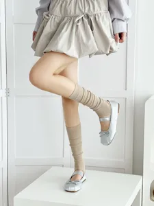 Stylish beige stirrup leg warmers paired with ballet style shoes for women spring fashion.