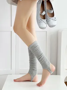 Grey stirrup leg warmers for women, ballet core style knitted hosiery detail view.