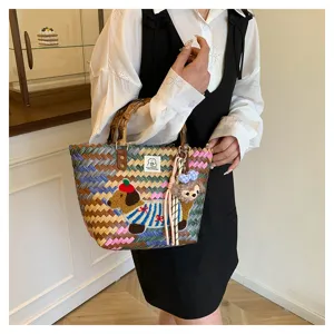 Borsa a mano intrecciata chic con manici in bambù e ricamo di bassotto per le vacanze estive.