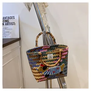 Dettaglio squisito della borsa intrecciata bassotto con design colorato e manico.