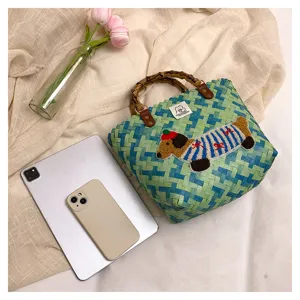 Borsa intrecciata con manico in bambù e ricamo di bassotto per vacanze estive.