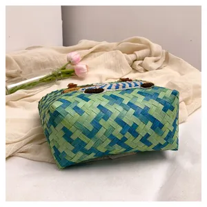 Vista dettagliata della borsa a cestino intrecciata colorata con vivace trama blu e verde.