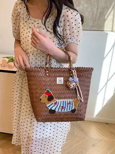 Borsa intrecciata con manico in bambù, simpatica toppa bassotto e design da spiaggia chic.