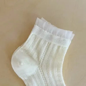 Vue détaillée de chaussettes courtes d'été pour femmes en filet blanc avec volant.