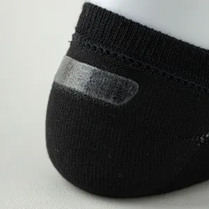 Nahaufnahme des Anti-Rutsch-Silikongriffs an schwarzen atmungsaktiven Baumwoll-Herrensocken.