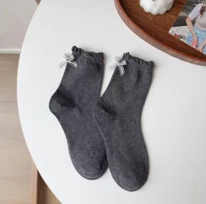 Süße graue Damensocken mit Rüschen und kleinen silbernen Schleifen für einen süßen Look.