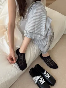 Close-up detail of women's summer thin breathable lace bow boat socks in black design style.