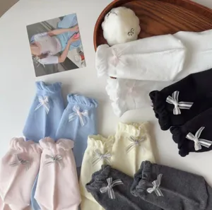 Detailaufnahme süßer Socken mit Rüschen und Schleifen in verschiedenen Pastellfarben.