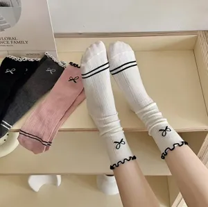 Balletcore cotton mid-tube socks with black ruffles and cute bows for women, sweet style.