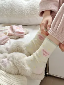 Cozy fuzzy winter sleep socks detail view, soft plush fleece lined cute pink heart design.