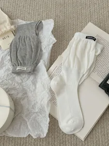Vista di dettaglio di calze lunghe slouchy minimaliste, calze a costine tinta unita.