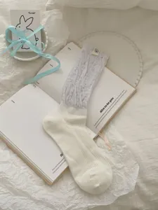 Korean style sheer ruffled cuff mid-tube women socks with cute fabric label detail.