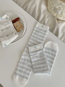 Close-up detail of stylish blue and white striped socks and floral ruffle socks arranged nicely.