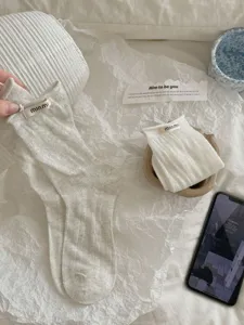 Closeup detail of Korean style cotton socks with hollow knit pattern and cute roll cuff.