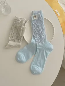 Detailed shot of Korean style cute knit tube socks with floral fabric labels on a table.