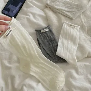 Women's Korean style mid-calf cotton socks with hollow knit pattern and rolled cuffs.
