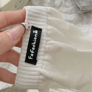 Calze lunghe e morbide in maglia bianca con una elegante etichetta nera del marchio.