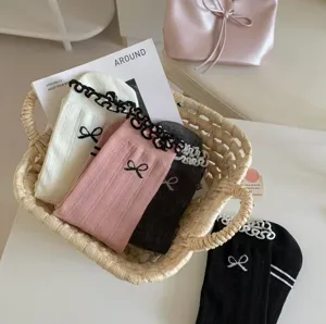 Cute balletcore cotton mid-tube socks with lace ruffle and bow details for women.